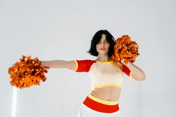 Person performing a calm, focused movement in a bright studio.